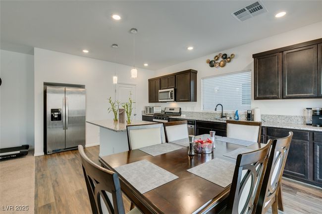 Kitchen featuring recessed lighting, light wood finished floors, visible vents, dark brown cabinetry, and appliances with stainless steel finishes | Image 5