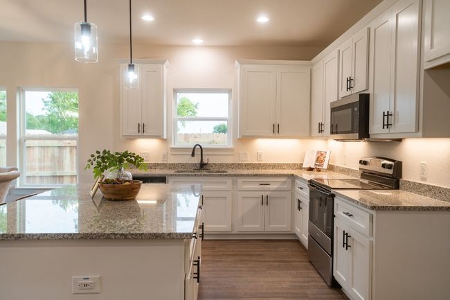 Kitchen featuring electric stove, a sink, healthy amount of natural light, white cabinets, and recessed lighting | Image 11