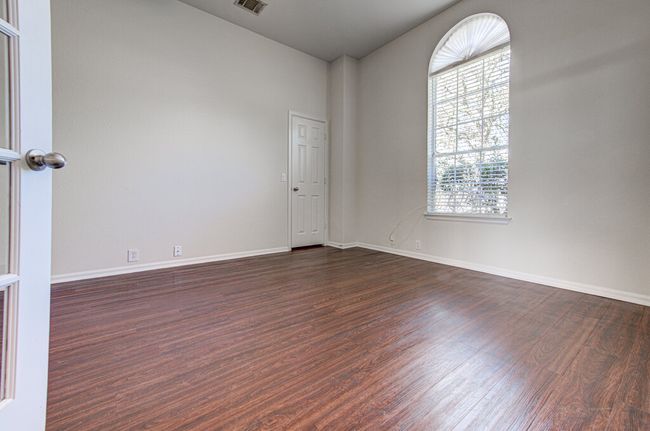 Spare room with dark wood-type flooring, visible vents, and baseboards | Image 7