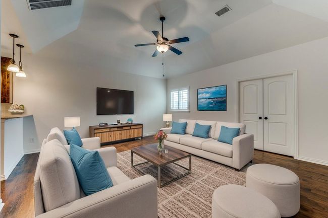 Game room with ceiling fan, lofted ceiling, wood finished floors, and visible vents | Image 16