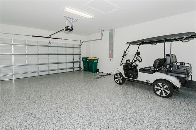 Garage featuring a garage door opener and electric panel | Image 32
