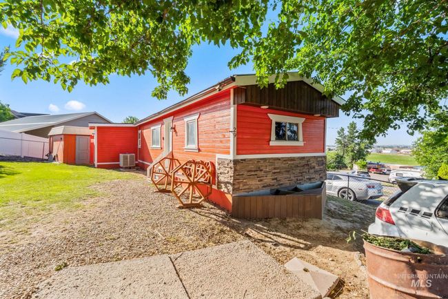 View of home's exterior with a storage shed and stone siding | Image 21