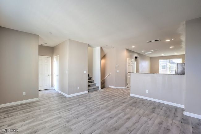 Empty room featuring stairway, light wood finished floors, baseboards, visible vents, and recessed lighting | Image 14