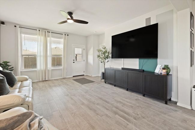 Living area featuring a ceiling fan, light wood-style flooring, and baseboards | Image 17