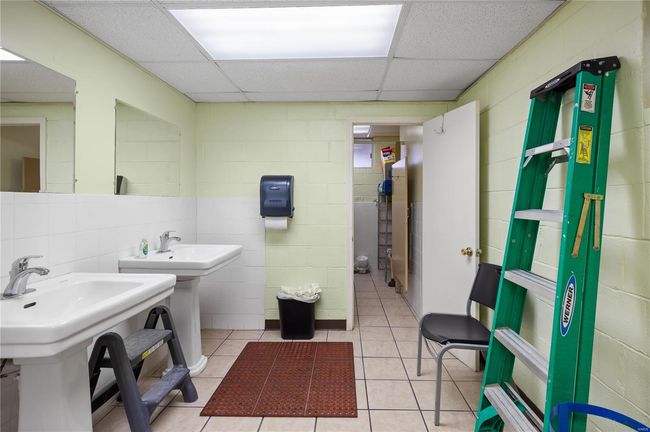 Bathroom with tile patterned floors, a paneled ceiling, and two sinks | Image 21