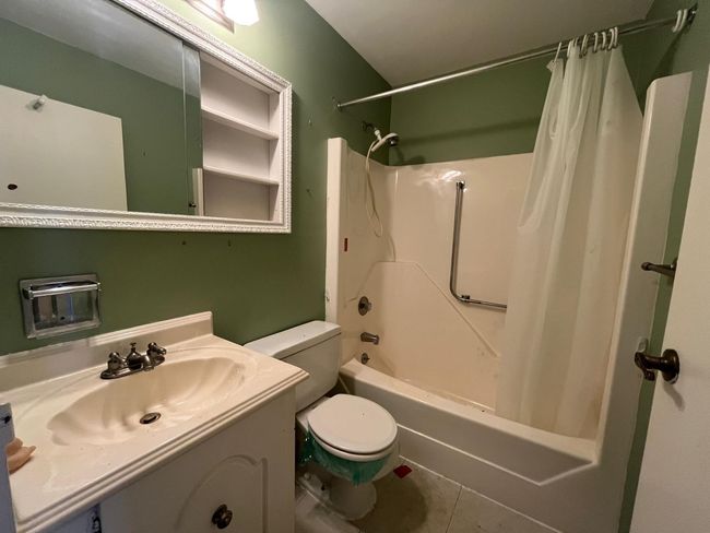 Bathroom with shower / tub combo with curtain, toilet, vanity, and tile patterned flooring | Image 8