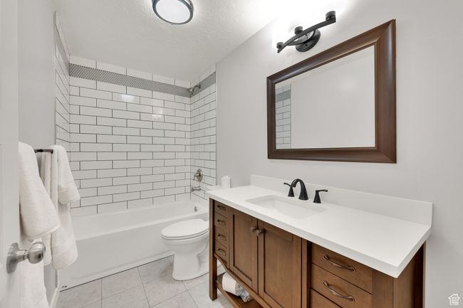 Bathroom with vanity, washtub / shower combination, a textured ceiling, and tile patterned flooring | Image 27