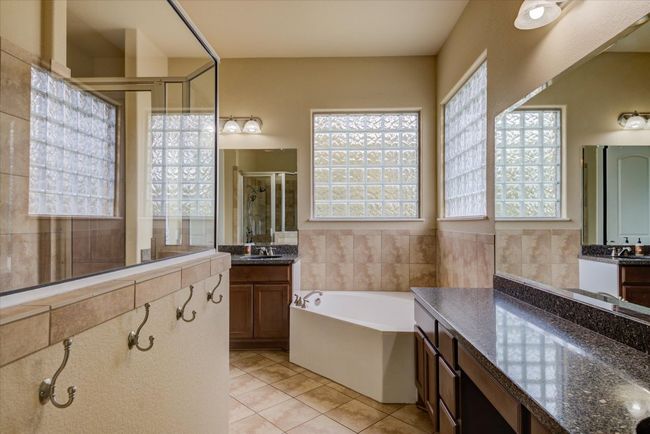 Primary bathroom with a garden tub, tile patterned floors, two vanities, and a walk-in shower | Image 19