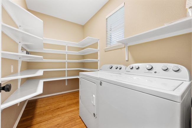 Washroom with light wood-style flooring, laundry area, and separate washer and dryer | Image 15