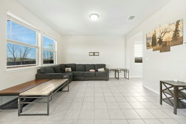 Living room featuring light tile patterned floors, baseboards, and visible vents | Image 11