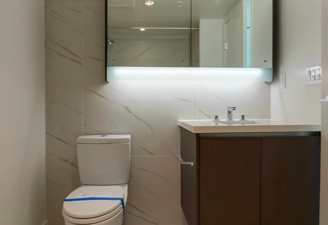 Bathroom with toilet, vanity, and tile walls | Image 16