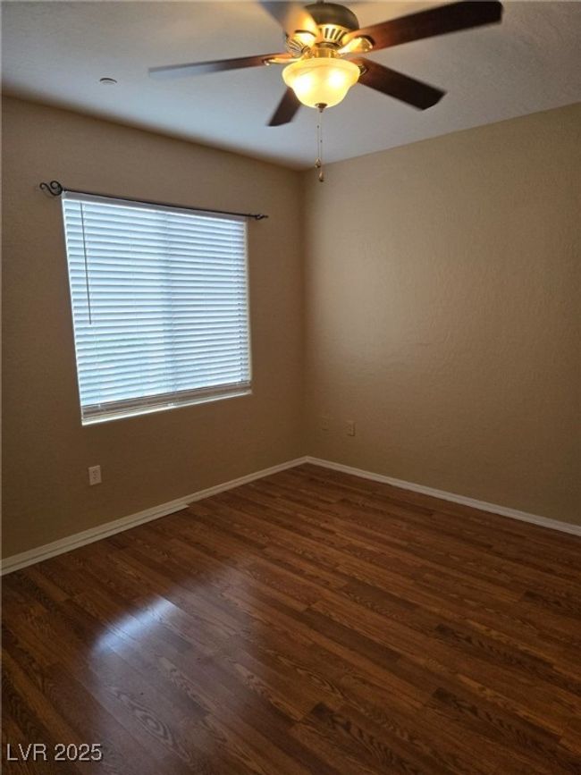 Unfurnished room featuring ceiling fan, baseboards, and dark wood-type flooring | Image 19