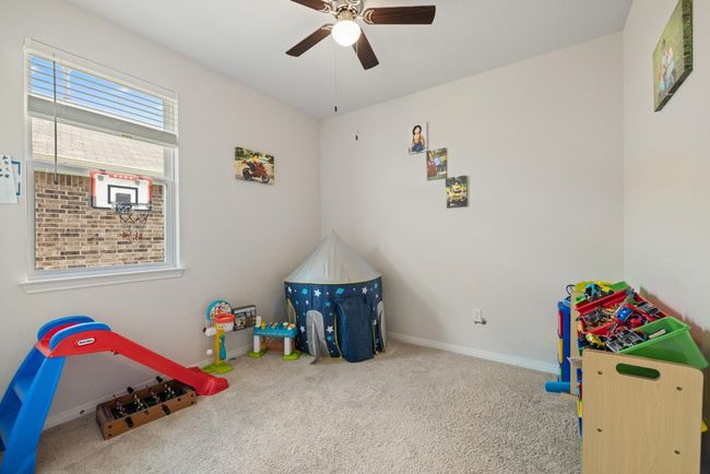 Rec room with carpet floors, a ceiling fan, and baseboards | Image 20