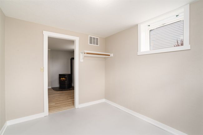 Unfurnished bedroom featuring a wood stove and baseboards | Image 28