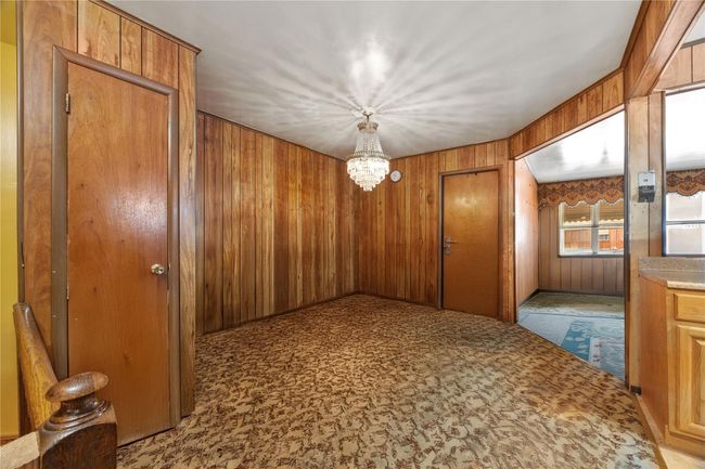 Corridor featuring wood walls and a chandelier | Image 11