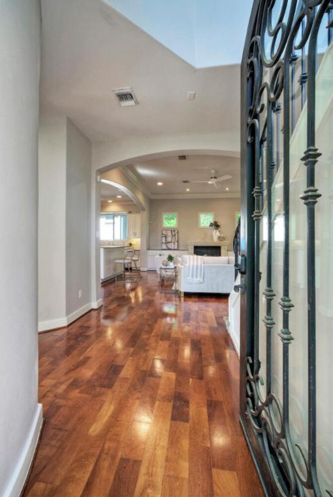 Elegant foyer featuring arched walkway, tall ceilings, hardwood floors gleaming with abundant natural light | Image 10