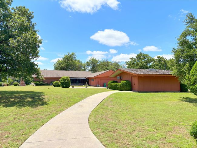 View of grassy yard with a garage and concrete driveway | Image 8