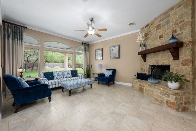 Living area with ceiling fan, ornamental molding, and a fireplace | Image 13