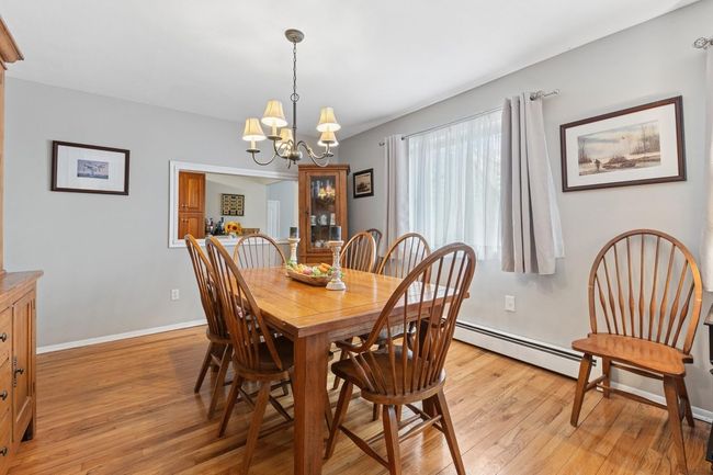 Dining space with light wood-style floors, an inviting chandelier, and baseboards | Image 11