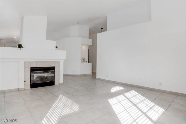 Living room featuring a vaulted ceiling & fireplace | Image 6