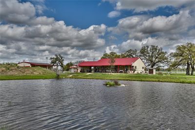 View of fishing pond and back of main house, south barndo to the left. Zipline off to the right. | Image 1