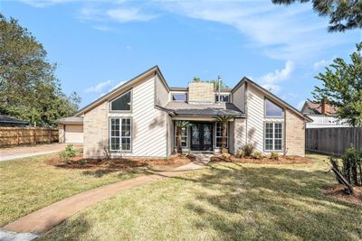 Stunning curb appeal! This home's exterior boasts clean lines, a beautifully manicured lawn, and a welcoming front entrance that sets the tone for the comfort within. | Image 1