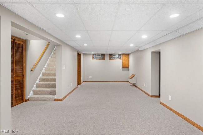 Basement featuring a drop ceiling and light colored carpet | Image 24