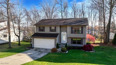 Bi-level home with a front lawn and a garage | Image 1