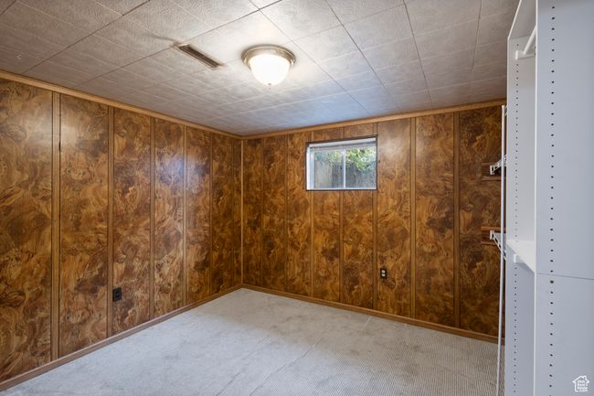 Carpeted spare room with wood walls | Image 28