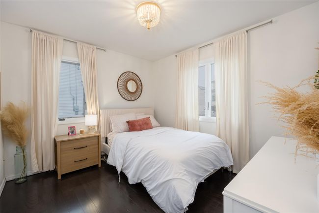 Bedroom with dark wood finished floors and a chandelier | Image 31