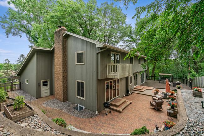 Private backyard oasis featuring tiered patios, lush wooded views, and multiple seating areas perfect for entertaining or relaxing outdoors. | Image 30