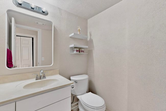Half bathroom with a textured wall and vanity | Image 21