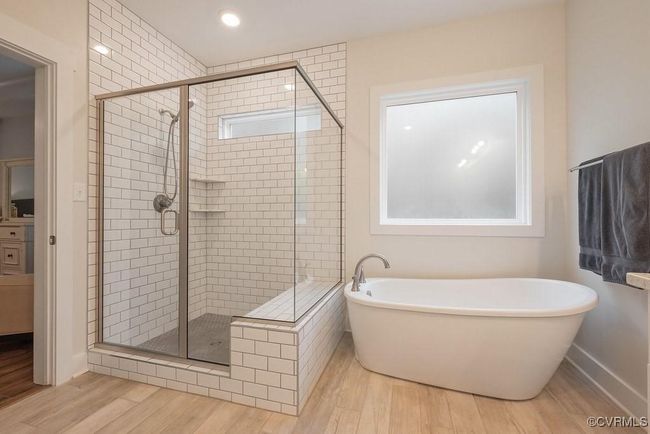 Full bath featuring wood finished floors, a freestanding bath, and a stall shower | Image 19