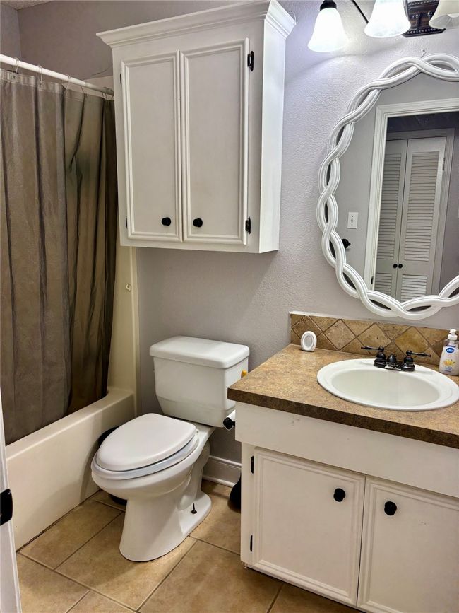Full bathroom with vanity, tile patterned floors, and shower / bath combo | Image 14