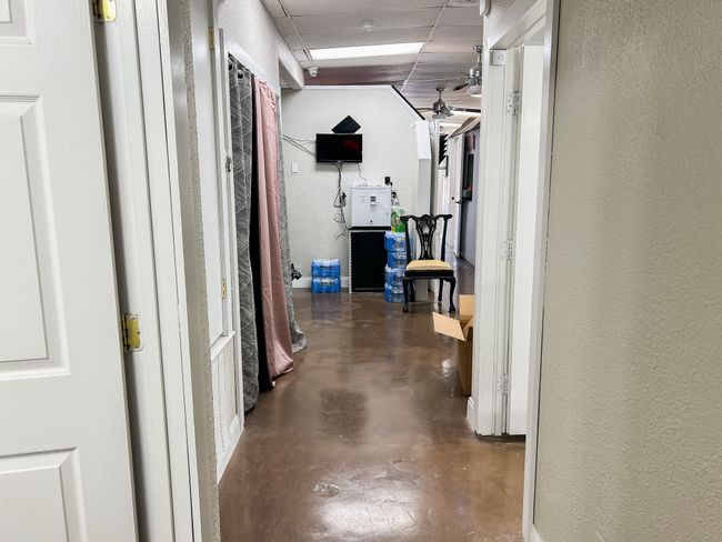 Corridor with a textured wall, a drop ceiling, and finished concrete floors | Image 21