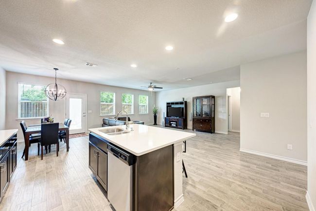 Kitchen with stainless steel dishwasher, light countertops, light wood-type flooring, recessed lighting, and a textured ceiling | Image 5