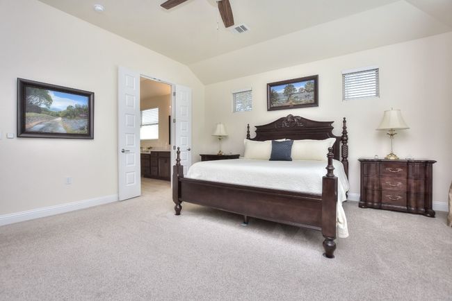 Bedroom with lofted ceiling, baseboards, visible vents, and light carpet | Image 22