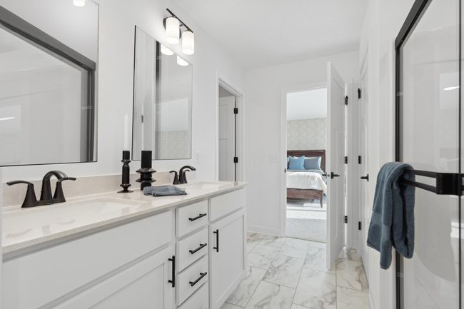 (Photo of a decorated model, actual homes finishes will vary) An extension of the primary suite, this private and spacious bath contains a double-vanity. | Image 11
