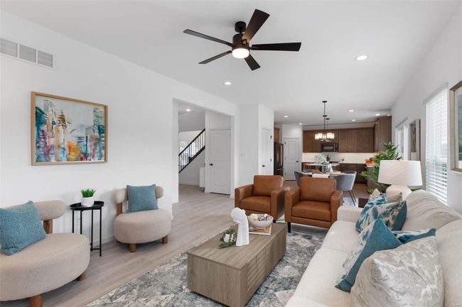 Living room featuring ceiling fan with notable chandelier and light hardwood / wood-style flooring | Image 5