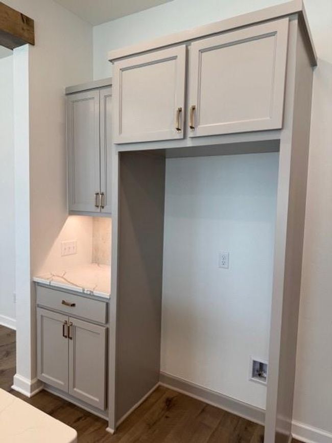 Kitchen featuring light stone counters, baseboards, dark wood-style floors, and gray cabinets | Image 15
