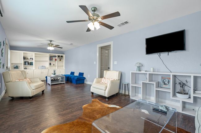 Living room with a ceiling fan and wood finished floors | Image 8