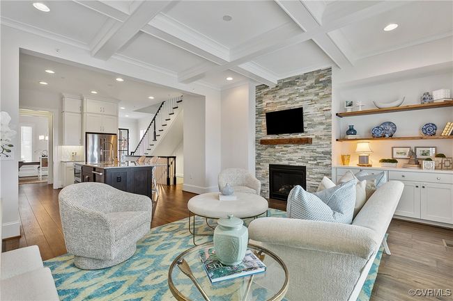 Living area with stairs, a fireplace, beam ceiling, and wood finished floors | Image 12