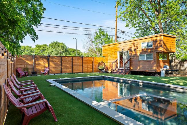 View of swimming pool with entry steps, a lawn, and a fenced backyard | Image 32