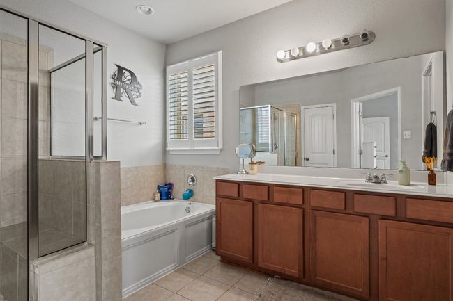 Bathroom featuring a shower stall, double vanity, a garden tub, and tile patterned flooring | Image 20