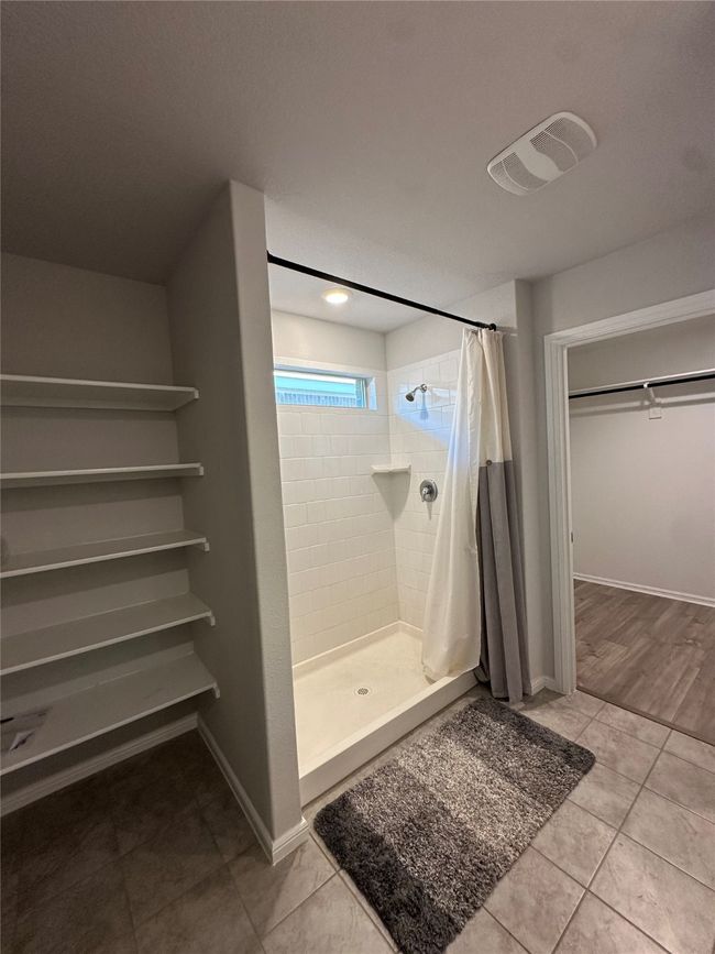 Bathroom with baseboards, tile patterned flooring, visible vents, and a stall shower | Image 21