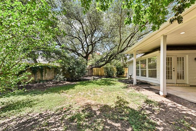 View of fenced backyard with mature trees | Image 33