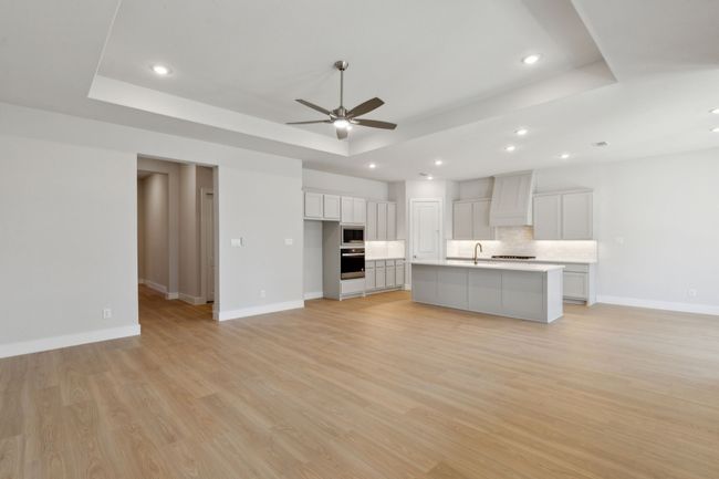 Kitchen with a raised ceiling, stainless steel appliances, a ceiling fan, open floor plan, and recessed lighting | Image 11