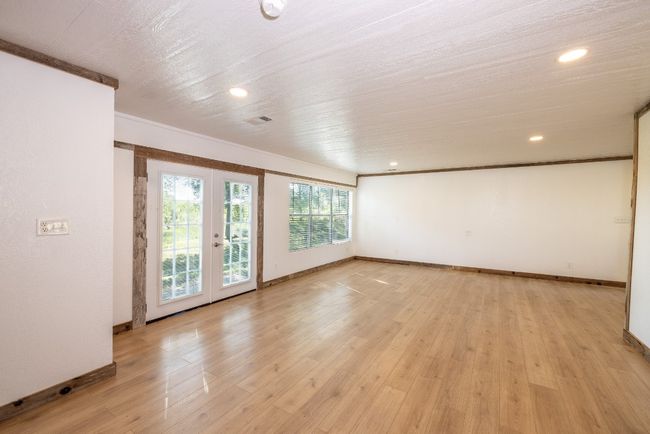 Unfurnished room with crown molding, light wood-style flooring, recessed lighting, french doors, and baseboards | Image 6