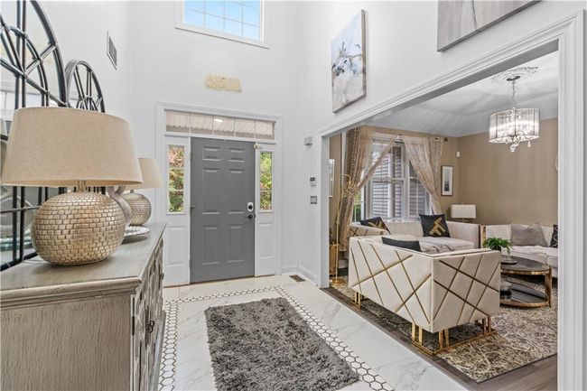 Foyer with healthy amount of natural light, a chandelier, light marble finish flooring, and baseboards | Image 16