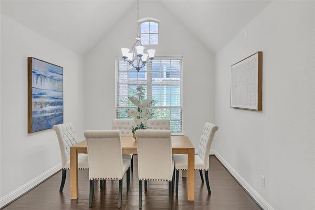 Dining room with a chandelier, dark wood finished floors, and lofted ceiling | Image 6
